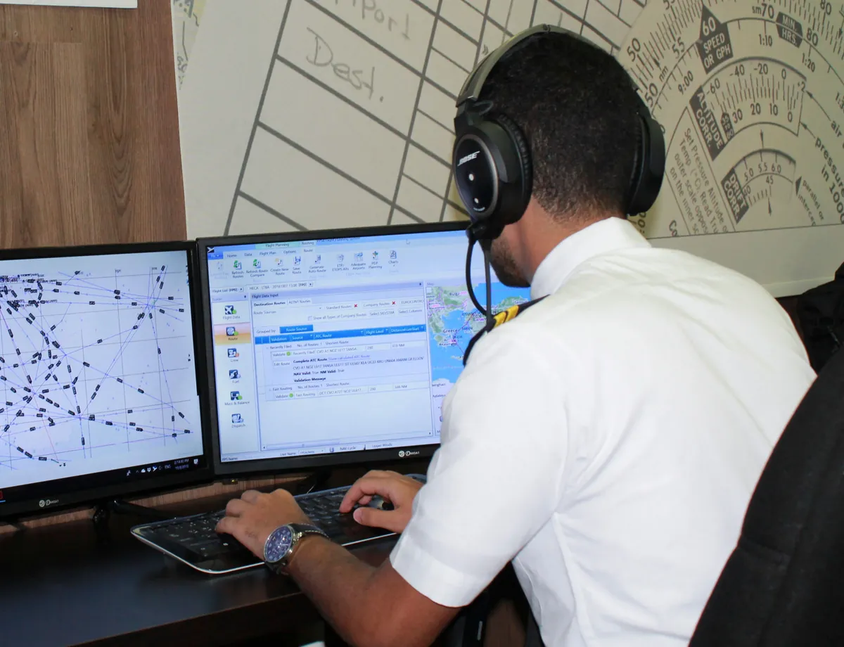 Flight operations trainee planning a route at the dispatch workstation